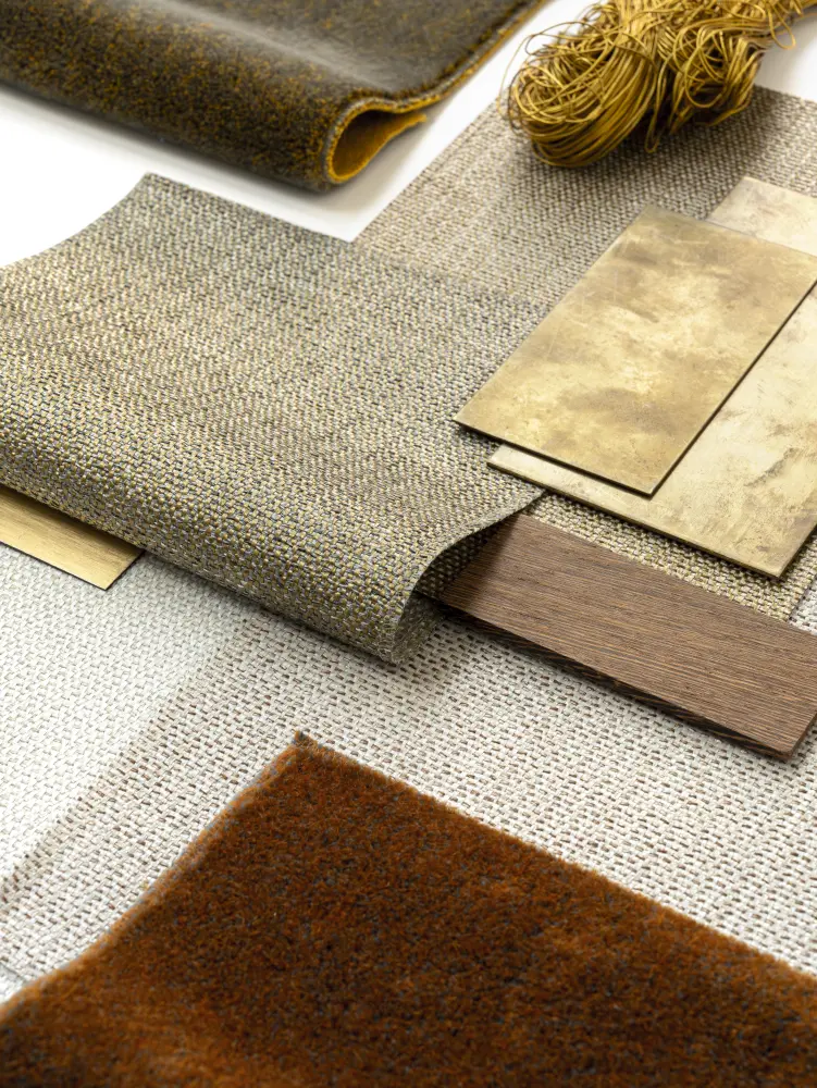 Vescom Amber woven textile wallcovering collage with pronounced weave texture styled with brass sheets, wood and yarn.