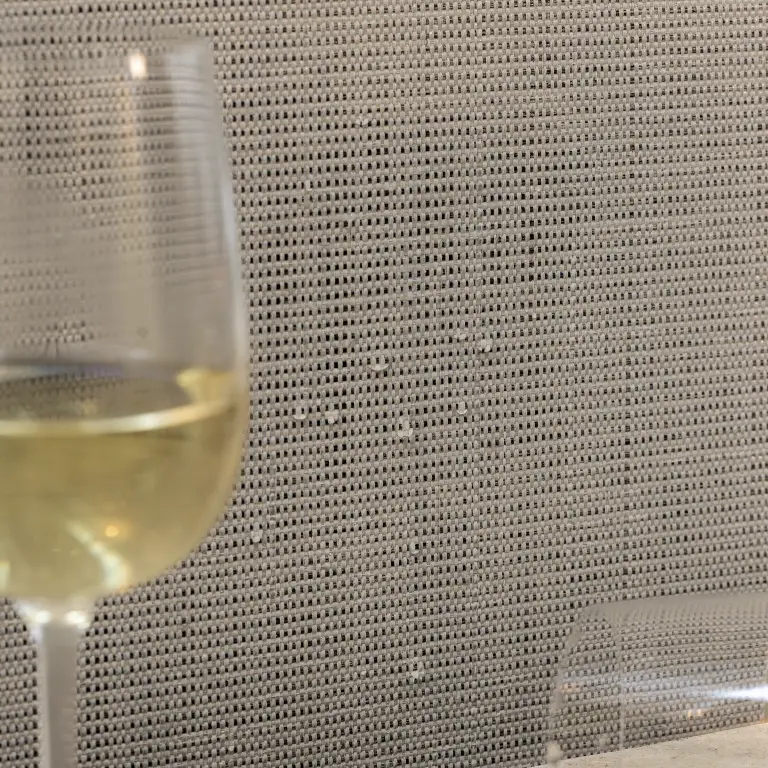 Vescom Birch woven textile wallcovering with subtle slub texture and architectural grid showing water droplets on the surface