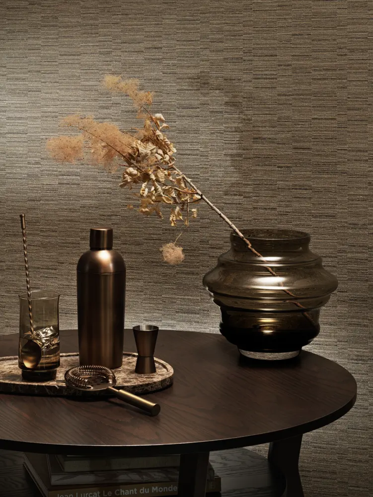 “Vescom Viveo textile wallcovering with a jacquard woven texture and subtle irregular colour variation creating a lively surface with soft sheen, shown on interior walls behind a styled table setting with glassware and decorative vase